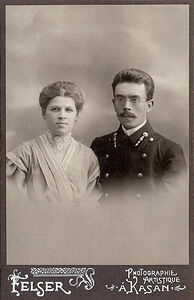 Коллежскiй секретарь съ супругой.  Кабинетъ портретъ.  На лицевой сторонѣ:  Felser Photographie Artistique  a’ Kasan.  На оборотной сторонѣ:   Photographie Felser Kazan  Rue Voskresenkaja  Nouveau Passace  Фотографiя С. Фельзер Казань  Негативы Сохраняются. (Собранiе А.Л. Красоткина. Томъ XX).