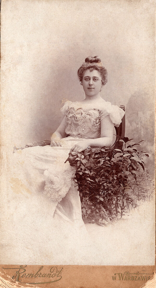 Портретъ дѣвушки въ креслѣ.  Фото: 19х11 см  Бланкъ: 20,8х11,3 см  На лицевой сторонѣ:  Rembrandt w Warszawie  На оборотной сторонѣ:  Fotografja  Artystyczna  Rembrandt   w Warszawie  Telefon № 660. (Собранiе А.Л. Красоткина. Томъ XVII).